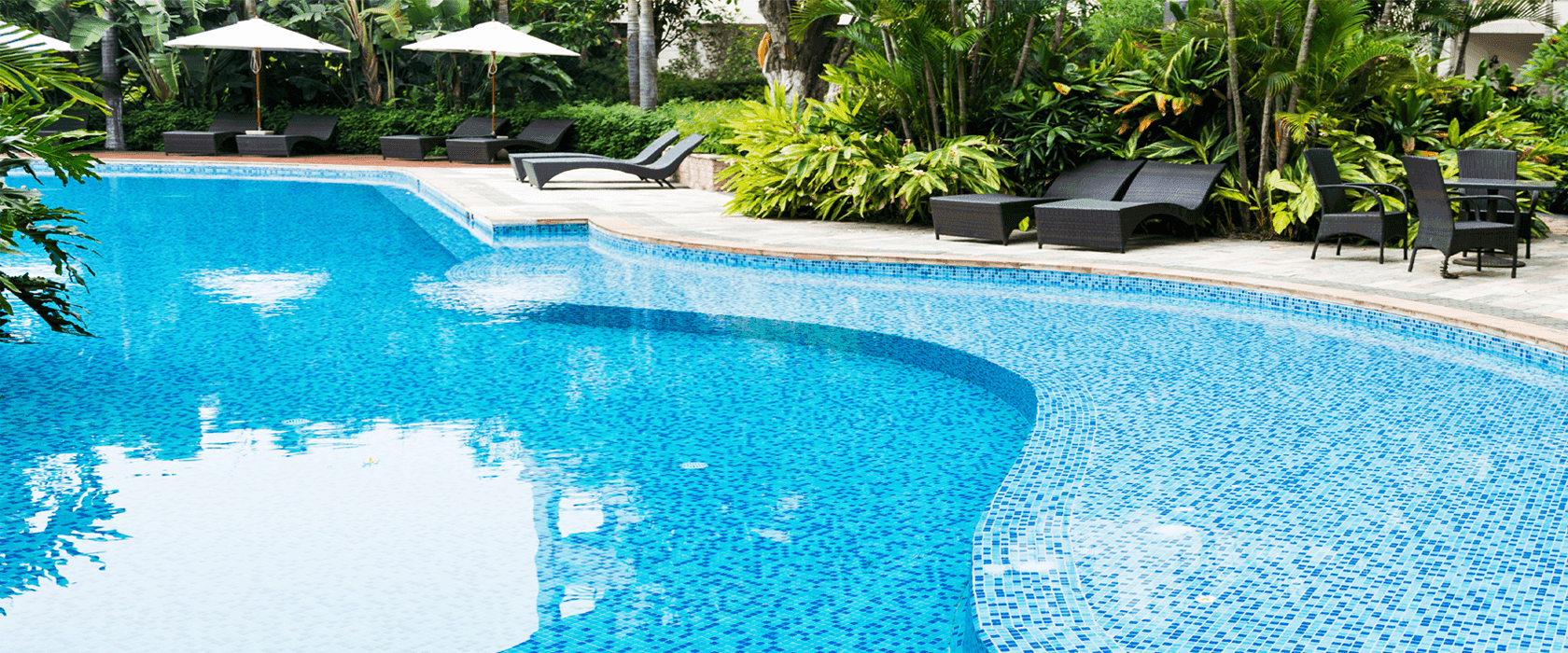 A pristine resort-style swimming pool surrounded by lush landscaping, maintained by SPS PoolCare